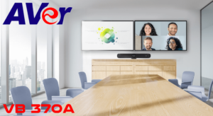 A modern meeting room featuring the AVer VB 370A video conferencing system, large displays showing participants, and a sleek wooden table with blue chairs.